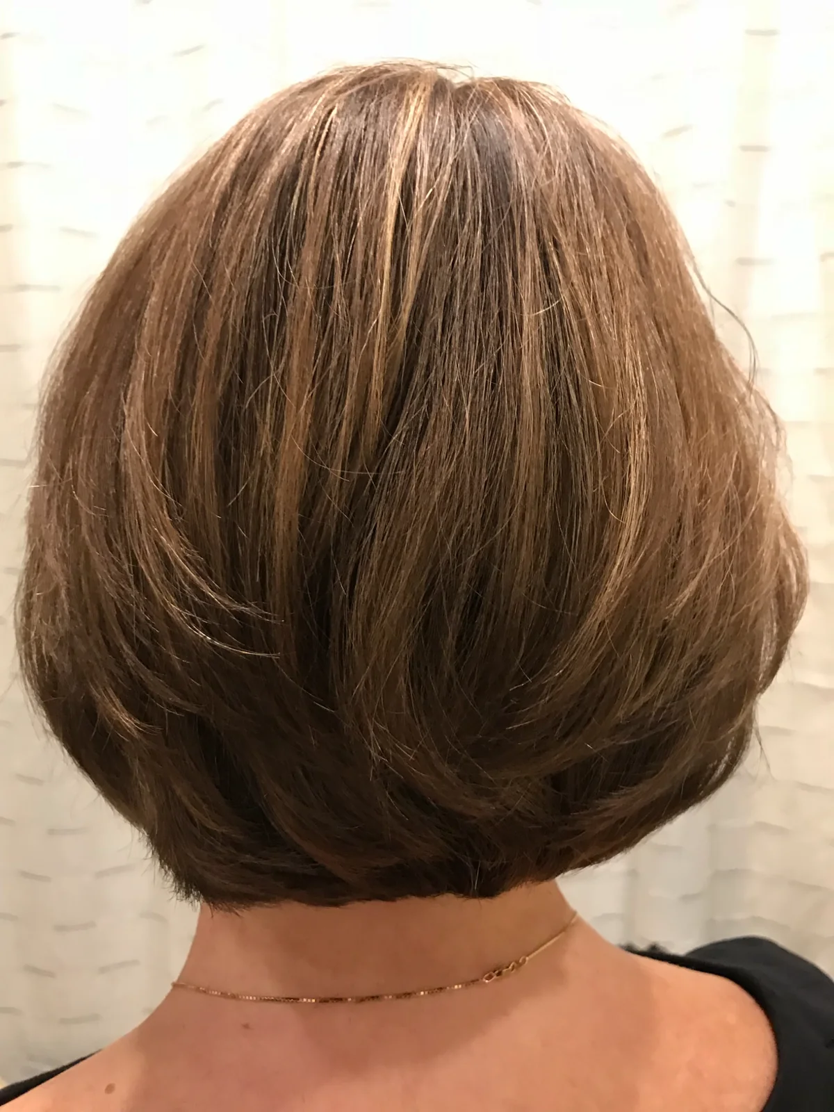 Smooth, rounded brunette bob photographed from behind