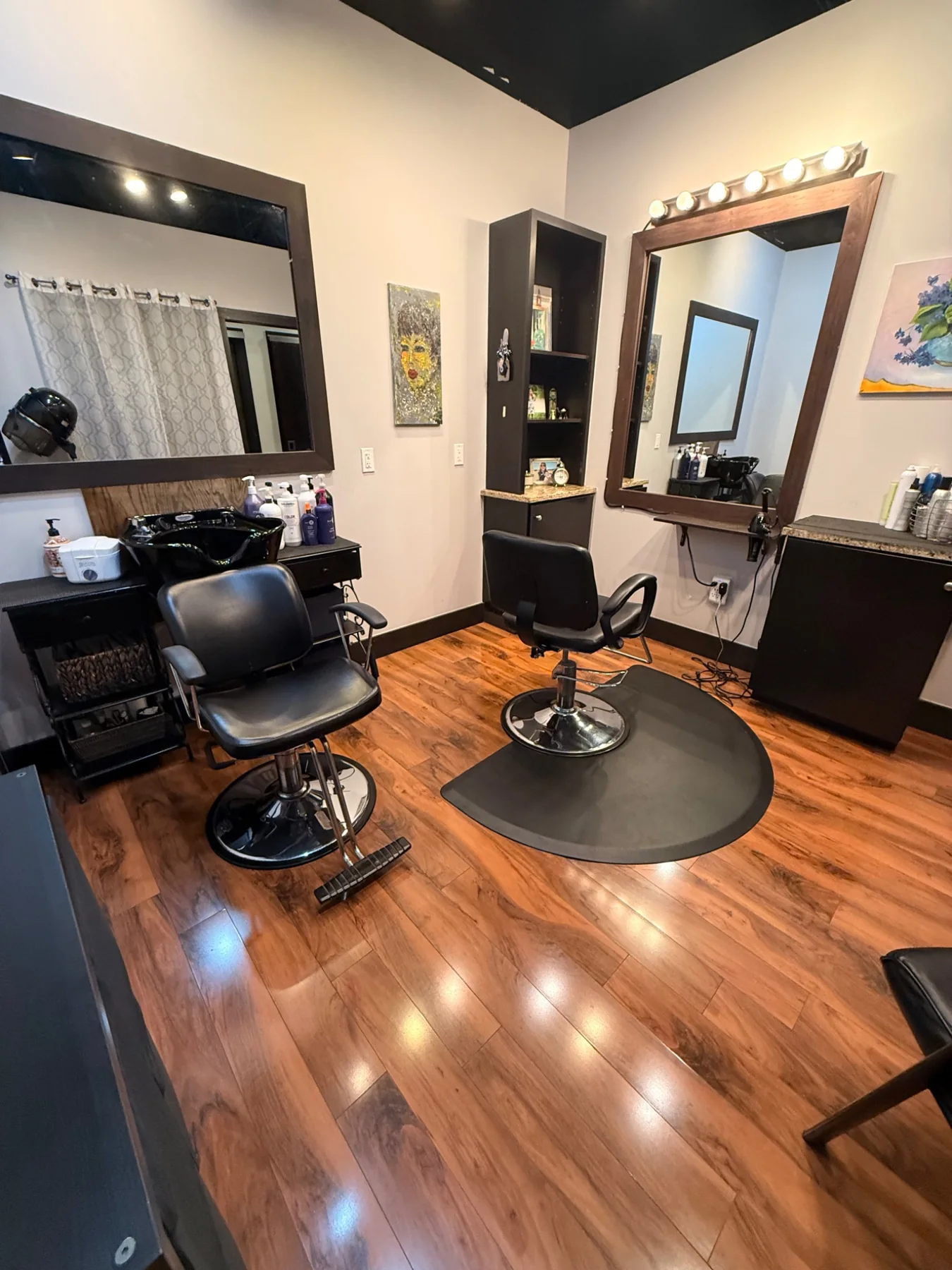 Mitra Hair Studio interior with styling stations and warm wood flooring